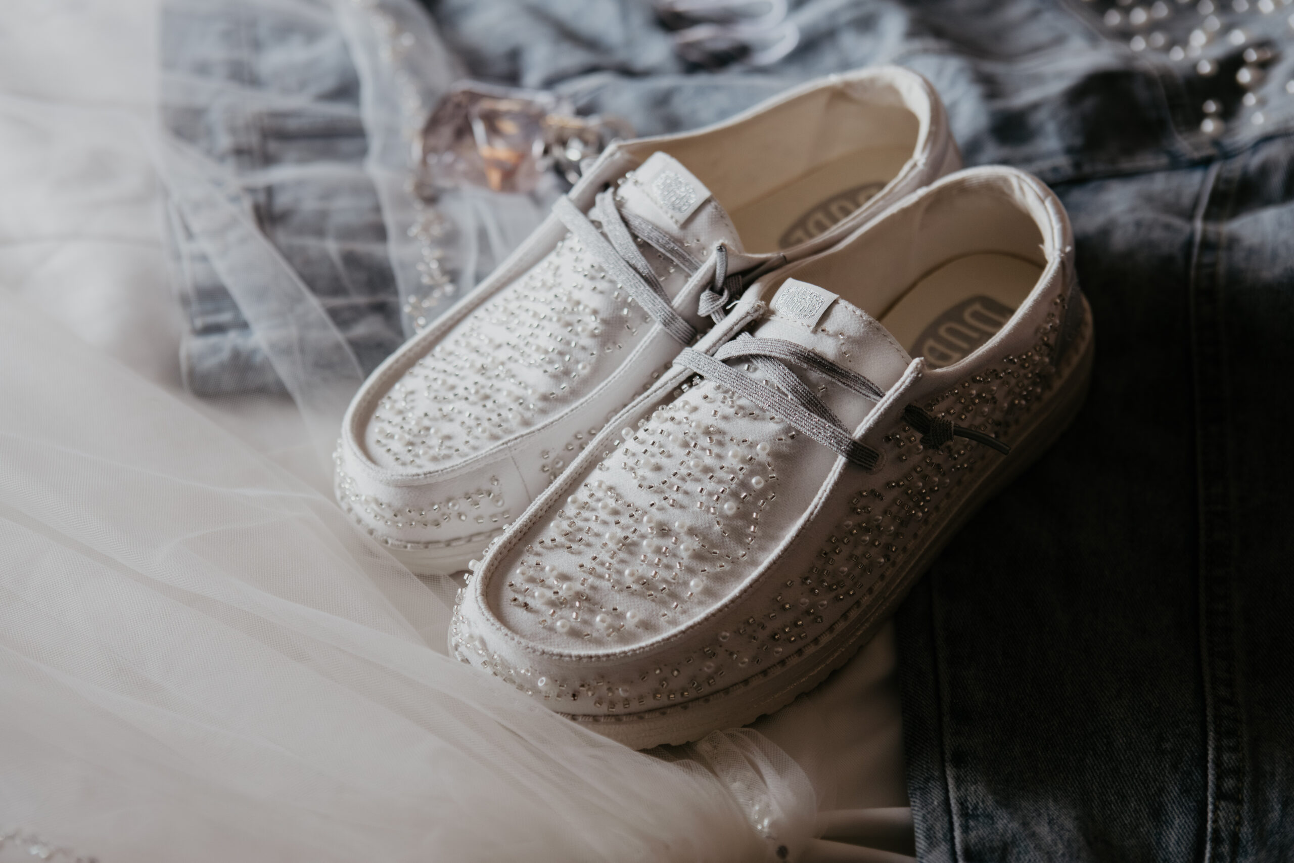 Beaded white bridal sneakers photographed on wedding day at Fenton Winery & Brewery in Michigan by Arielle Roth Photography