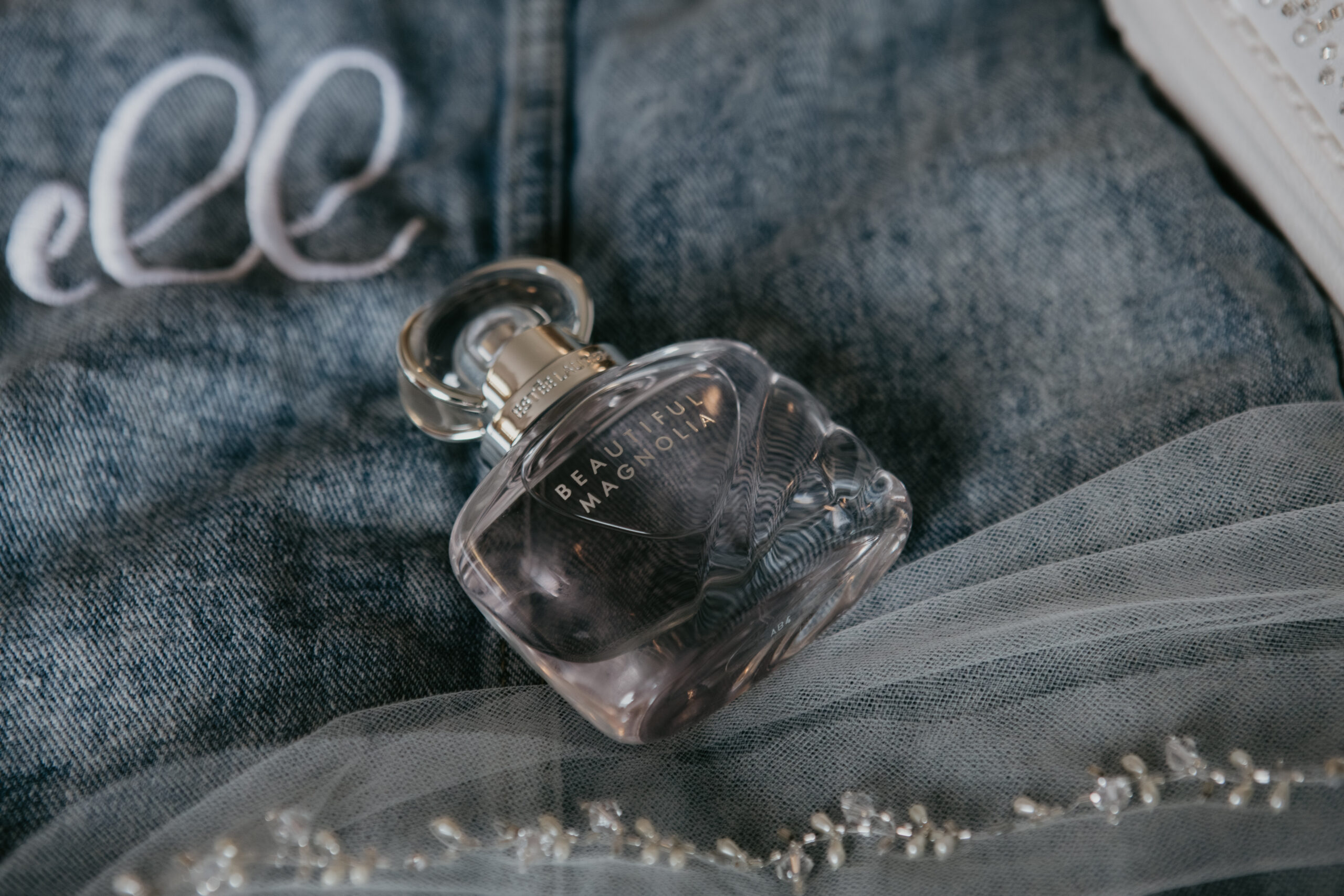 Beautiful Magnolia perfume bottle styled with bridal accessories before wedding at Fenton Winery & Brewery in Michigan captured by Arielle Roth Photography